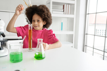 Mix race kid girl funny learning study science of of use microscope and test chemical with tube