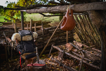 A bushcraft kuksa hand carved with gouges, with a hiking backpack at the background.