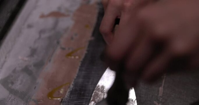 Making ice cream rolls on cold slab of steeel - close up on hands