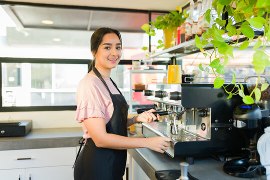 Attractive female barista smiling working in the coffee shop