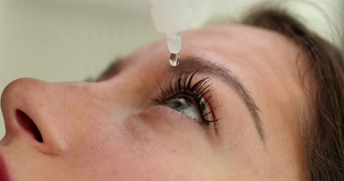 Woman patient dripping eye drops into eyes closeup 4k movie slow motion