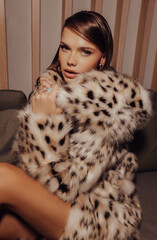 beautiful woman with dark hair in luxurious lynx fur coat