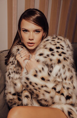 beautiful woman with dark hair in luxurious lynx fur coat