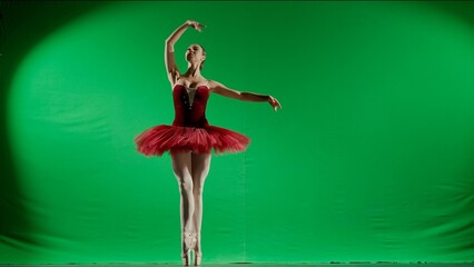Woman on chroma key background of green screen. Beautiful ballerina in red tutu and pointe shoes...