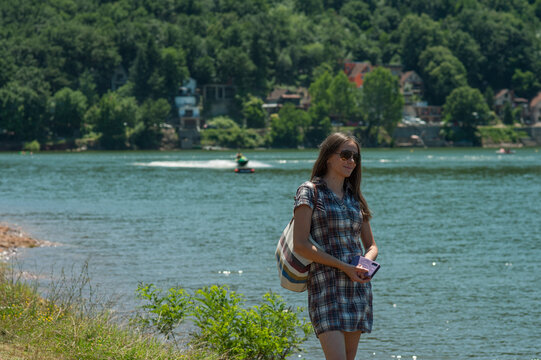 A young woman wearing a skirt is standing beside Bovan Lake (Bovansko Jezero).