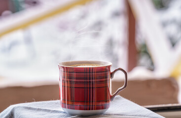 Black coffee in a cup on the windowsill, natural lighting, a winter snowy landscape in the background