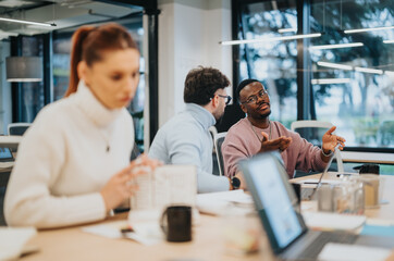 Multicultural business team discussing marketing strategy and competitive analysis. Creative people collaborating on budgeting and product development.
