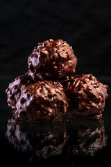 Delicious Chocolate Balls. Chocolate pralines with Nuts handmade sweets on luxurious black background