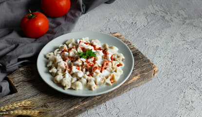 Turkish traditional food ravioli with yoghurt and tomato sauce in plate, manti