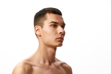 Handsome young brunette man with short hair, spotless perfect skin standing shirtless against white studio background. Concept of male beauty, skin care, spa, cosmetology, men's health
