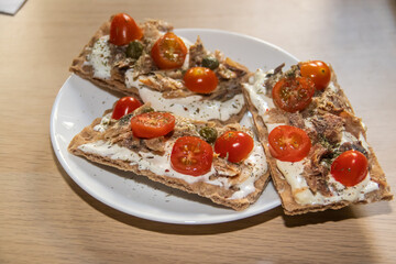 Assorted crispbread toasts with ripe vegetables and cheese, placed on table for heathy snack