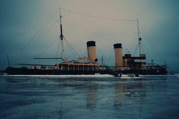 An old icebreaker ship is at the quay of the harbor. Oldest steam-powered icebreaker from the early...