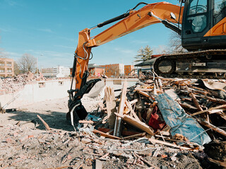 Large yellow industrial construction excavator or bulldozer equipment working at a demolition site....