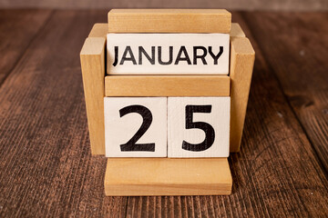 Cube shape calendar for January 25 on wooden surface with empty space for text,cube calendar for...