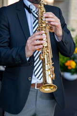 soprano saxophone in man hands in suit during event