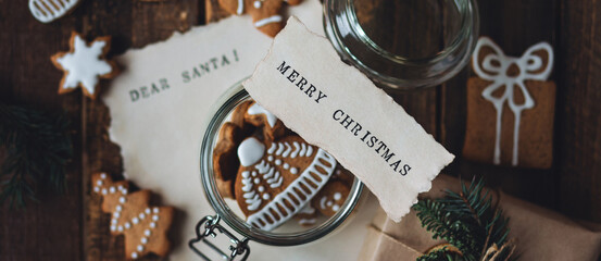 Banner. Delicious homemade gingerbread cookies in a glass jar with a note Merry Christmas on top....