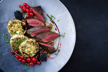 Traditionell gebratenes Rehrückenfilet mit Südtiroler Semmelknödel, Johannis und Brombeeren in...