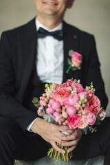 Elegance wedding decorations. Wedding bouquet for the bride and groom at an event. A stylish groom with a beautiful bouquet in his hands. Wonderful luxury wedding bouquet of different flowers.