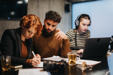 A business team working late at night in a corporate office, analyzing sales statistics and planning for sustainable business growth.