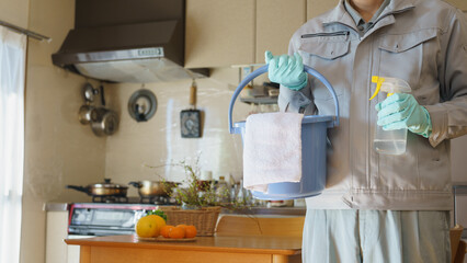 掃除道具を持つ作業服の男性　キッチン・ダイニング