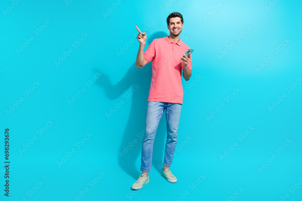 Poster Full body size photo of successful guy solve business tasks remote direct finger empty space using phone isolated on blue color background