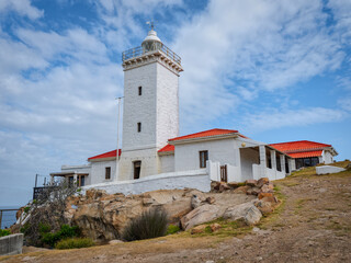 Fototapeta na wymiar Cape St Blaize Lighthouse during a summer afternoon with blue sky and white clouds, Mossel Bay, Western Cape, South Africa