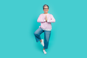 Full length photo of positive shiny lady wear striped sweater practicing yoga standing one leg...