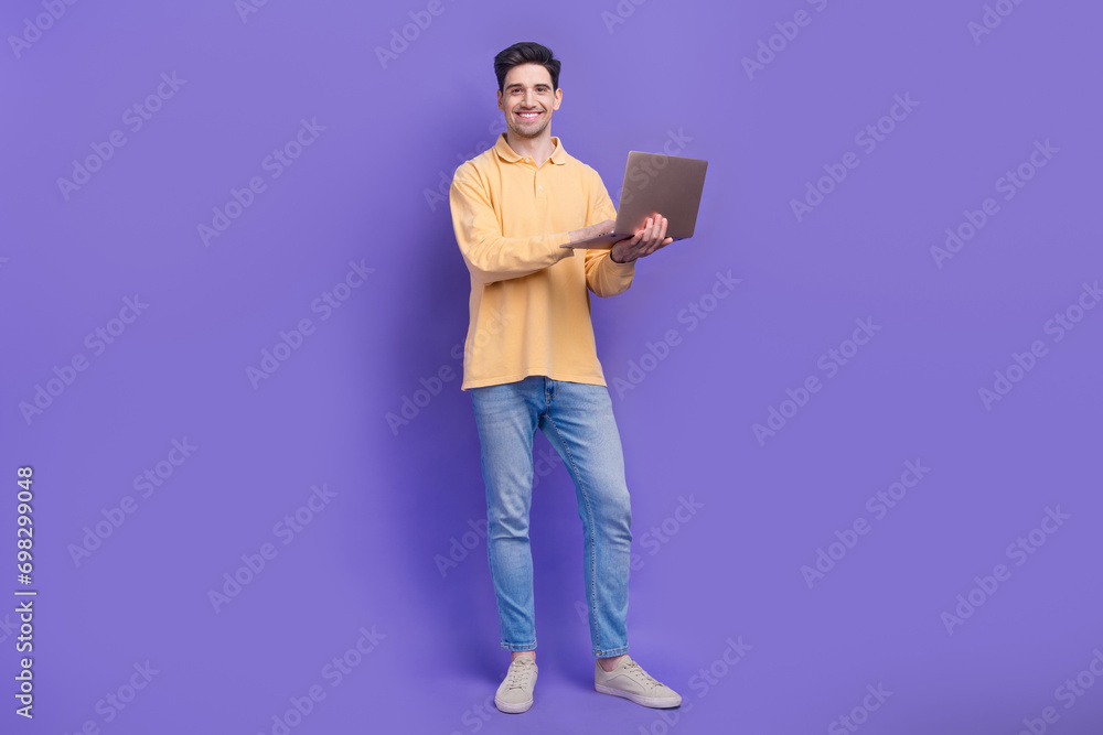 Sticker Full length photo of handsome young guy hold netbook work remotely dressed stylish yellow garment isolated on purple color background