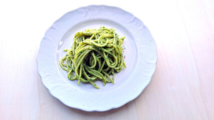 close-up, directly from above, of a plate with spaghetti with Genoese pesto