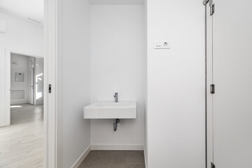 A bathroom with white porcelain sink, white pressed wood screen