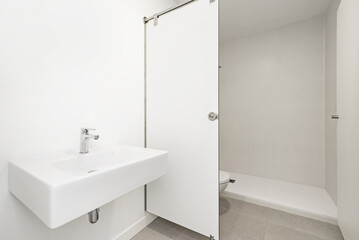 A bathroom with a white-walled shower cubicle