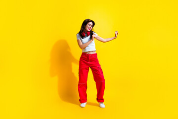 Fototapeta na wymiar Full length photo of sweet good mood woman dressed white t-shirt headphones dancing discotheque isolated yellow color background