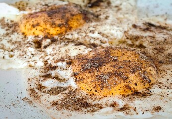 two eggs are on a pan with cinnamon sprinkled around them