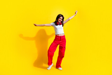 Full length photo of good mood adorable woman dressed t-shirt headphones arms sides having fun...