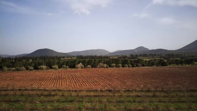 Ascending drone footage of the cultivated fields with dusk sky in the background in Tithorea, Greece