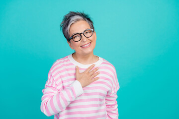 Photo of charming cute lady wear striped sweater hand arm chest smiling empty space isolated turquoise color background