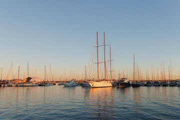 Beautiful sailboats are parked in Torrevieja at sunset.