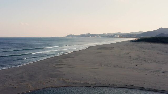 Drone flight over river and beach with waterbirds at sunset Miyazaki Japan