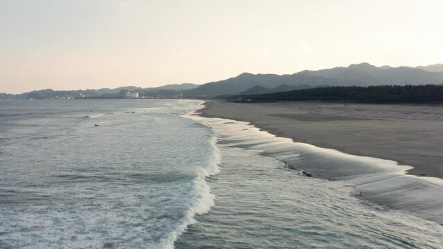 Drone flight over river and beach with waterbirds at sunset Miyazaki Japan