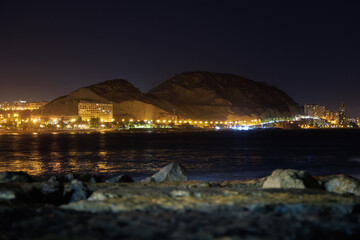 Panoramic view of night Alicante, streetlights, houses, and mountains.