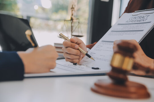 Lawyer, legal advisor, businessman brainstorming information on agreement details Business contracts in legal processing books for accuracy in contract documents. joint financial investment.