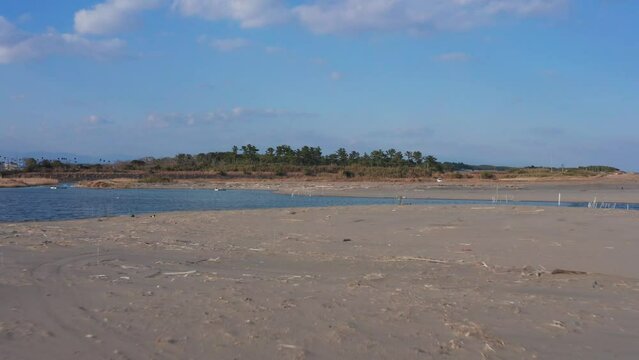 Drone flight over river and beach with waterbirds at sunset Miyazaki Japan