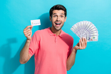 Photo amazed millionaire businessman wearing pink t shirt holding dollar banknotes he withdraw from...