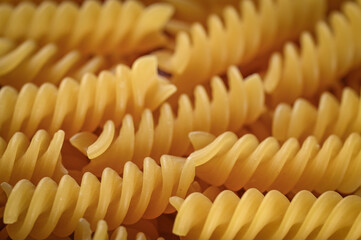 Raw spiral pasta on a rotating black plate.