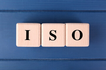 International Organization for Standardization. Cubes with abbreviation ISO on blue wooden table,...