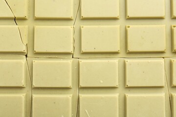 Broken tasty matcha chocolate bar as background, top view