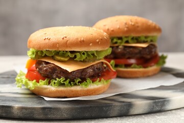 Tasty hamburgers with patties on light grey table, closeup