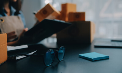 Startup small business entrepreneur or freelance Asian woman using a laptop with box, Young success Asian woman with her hand lift up, online marketing packaging box and delivery, SME concept.