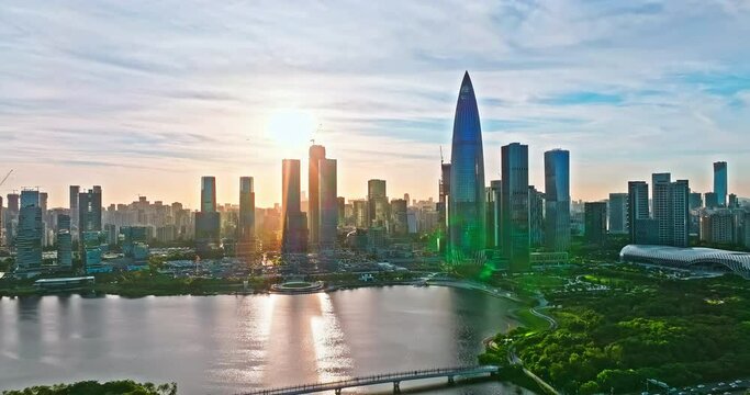 Aerial drone footage of Shenzhen skyline and modern building at sunset. Drone shooting backwards.