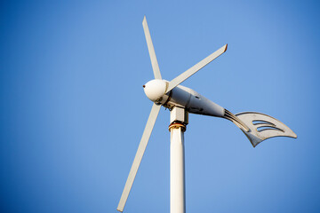 Wind turbine against blue sky © tang90246